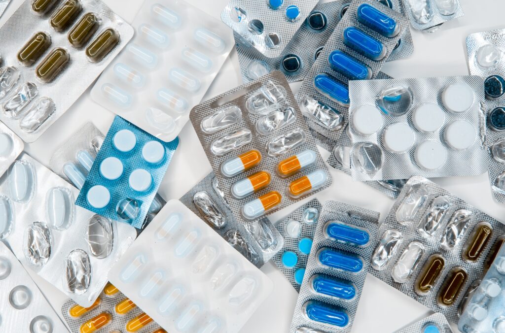 Photograph of different coloured medicine pills and tablets in blister packs.